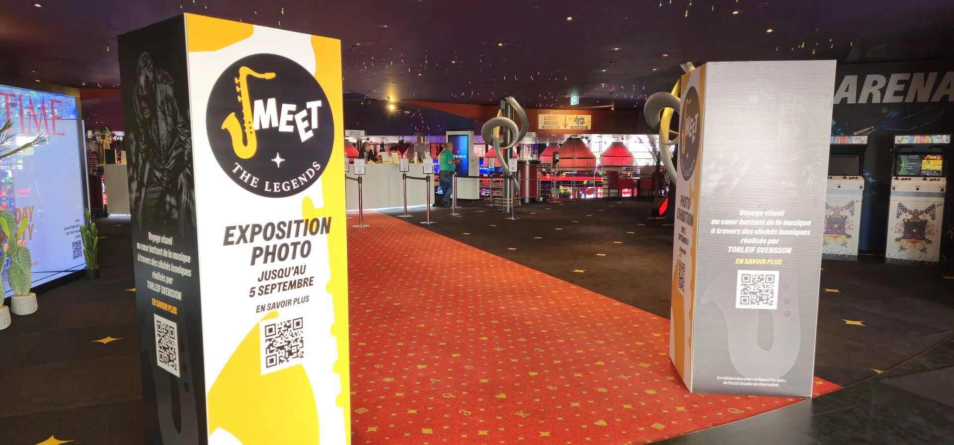 Totem promozionale di Meet the Legends posizionato all’ingresso del Casino Barrière Montreux, con richiamo alla mostra fotografica e QR code informativo